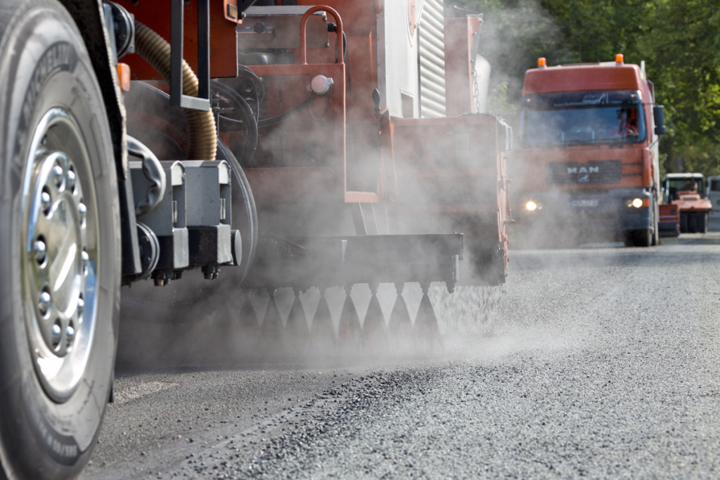 Fahrzeuge von MOT bei der Oberflächenbehandlung, Splitt wird abgestreut