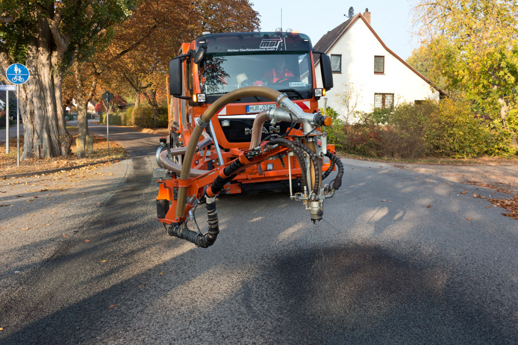 Fahrzeug von MOT mit Spritzarm von vorn, auf einer Ortsstraße